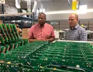 Solutions for cable operators | Picture of CableServ personnel looking at a batch of circuit boards - CableServ
